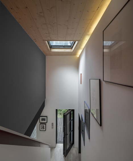 Blackened timber house extension with textured walls by Marchi Architectes