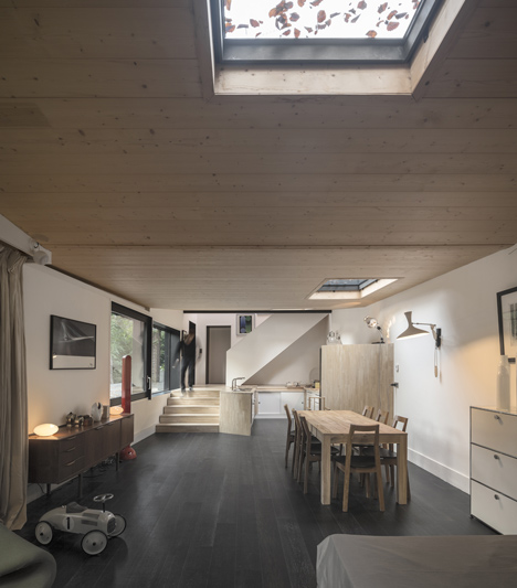Blackened timber house extension with textured walls by Marchi Architectes