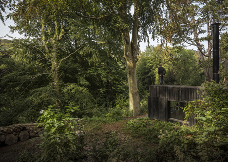 Blackened timber house extension with textured walls by Marchi Architectes