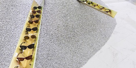 Golden girders protrude from piles of gravel to display sunglasses