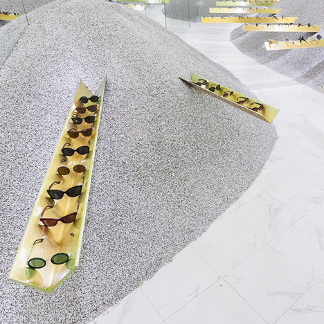 Golden girders protrude from piles of gravel to display sunglasses