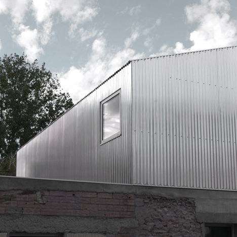 M03 house renovation by BAST contrasts old brick base with new metal extension