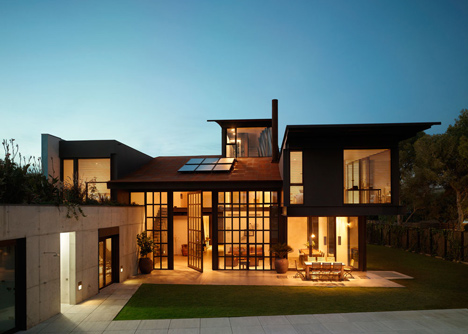 Pivoting steel doors lead into Studio Sitges, a house and photography studio in Spain by Olson Kundig