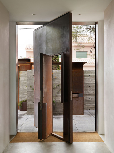 Pivoting steel doors lead into Studio Sitges, a house and photography studio in Spain by Olson Kundig