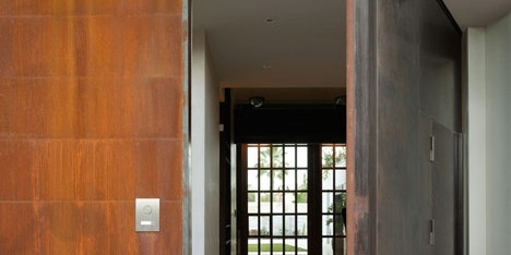 Pivoting steel doors lead into a house and photography studio by Olson Kundig