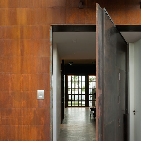 Pivoting steel doors lead into a house and photography studio by Olson Kundig