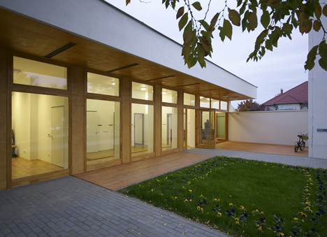 Church congregation hall by SAGRA Architects features a towering white bell tower