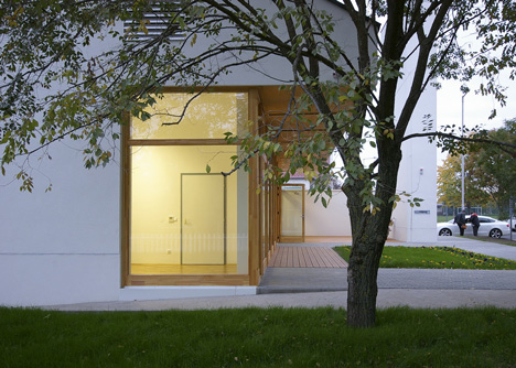 Church congregation hall by SAGRA Architects features a towering white bell tower