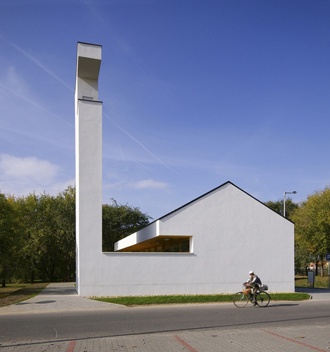 Church congregation hall by SAGRA Architects features a towering white bell tower