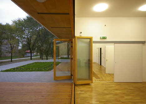 Church congregation hall by SAGRA Architects features a towering white bell tower