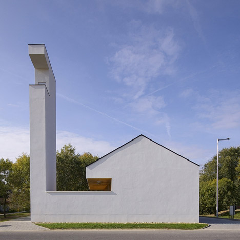 Church congregation hall by SAGRA Architects features a towering white bell tower
