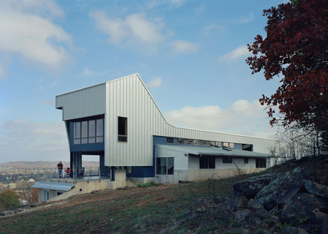 Angular metal roof wraps around a hilltop house by deMx architecture