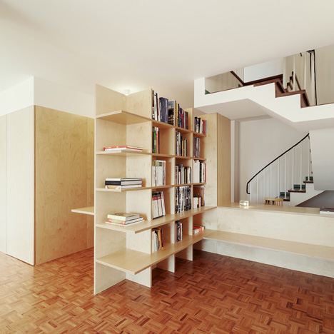 Wooden structures combine partitions and furniture inside home by João Branco