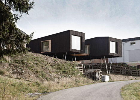 Black-painted S House by Hammerschmid Pachl Seebacher raised up on stilts