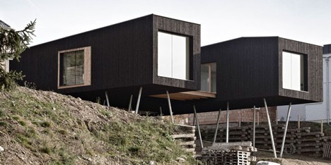 Black-painted S House by Hammerschmid Pachl Seebacher raised up on stilts