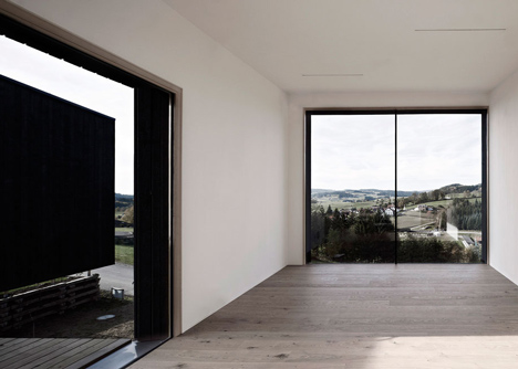 Black-painted S House by Hammerschmid Pachl Seebacher raised up on stilts