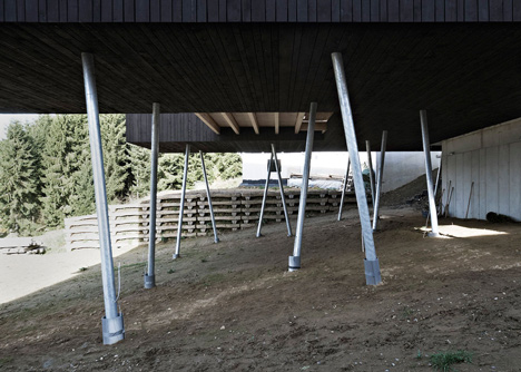 Black-painted S House by Hammerschmid Pachl Seebacher raised up on stilts