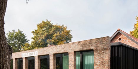 Brick colonnade screens renovated hunting lodge by DMOA Architecten