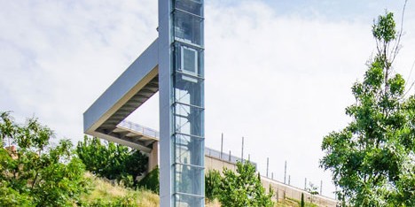 A steel-clad outdoor elevator connects the city and suburb in Pamplona by AH Asociados
