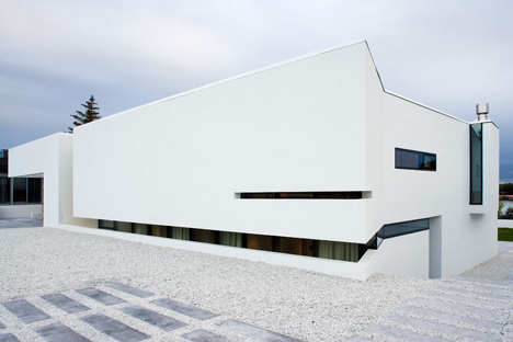Doorway hidden in volcanic stone wall of B25 house by PK Arkitektar