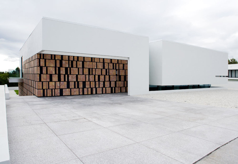 Doorway hidden in volcanic stone wall of B25 house by PK Arkitektar