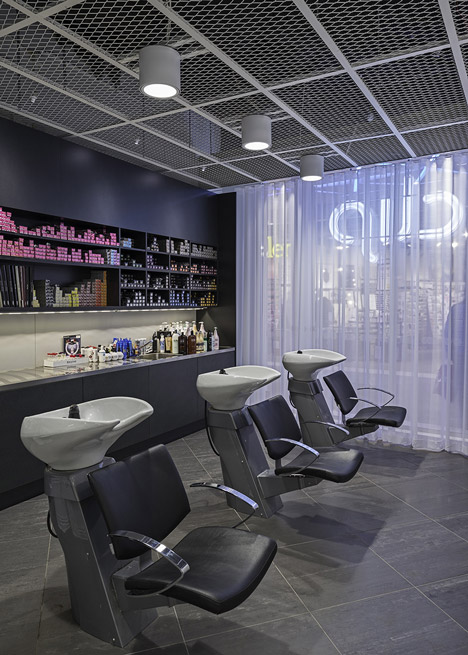 Green boxes cover the ceiling of Clip Drop In hair salon by Sweco Architects