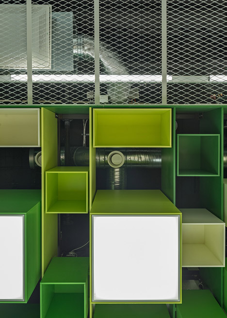 Green boxes cover the ceiling of Clip Drop In hair salon by Sweco Architects