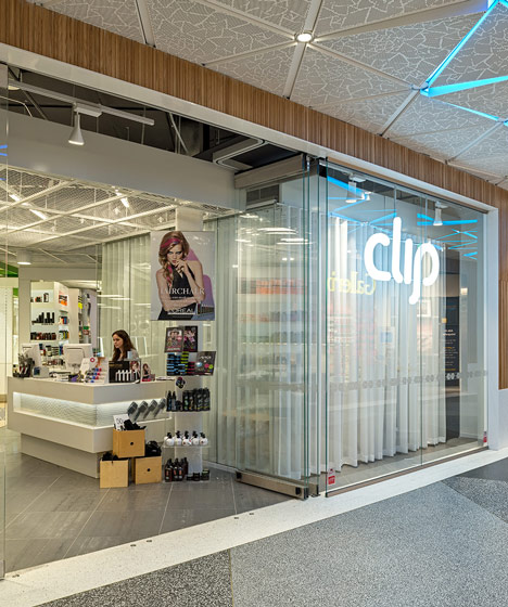 Green boxes cover the ceiling of Clip Drop In hair salon by Sweco Architects