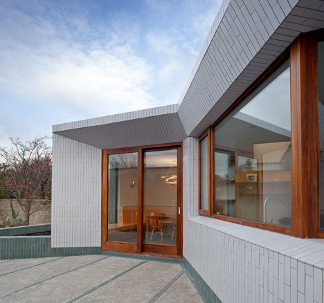 Tile-covered walls reflect light into Greenlea Road extension by GKMP Architects