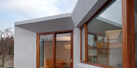 Tile-covered walls reflect light into Greenlea Road extension by GKMP Architects
