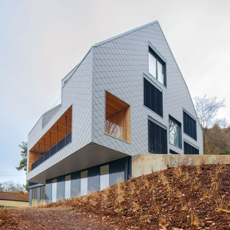 House B.A.B.E. by Destilat features windows dotted across shingle-clad facade