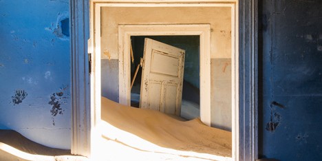 Ghost town engulfed by mounds of sand in photography by Romain Veillon