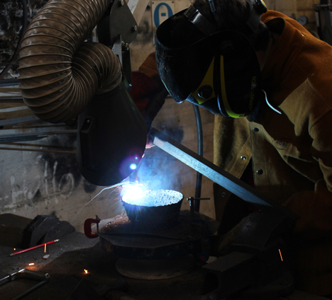 Josh Bitelli uses welding equipment to make containers from coils of molten steel