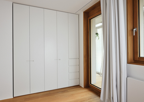 Studio 360 adds walls of modular shelving and storage to Slovenian apartment