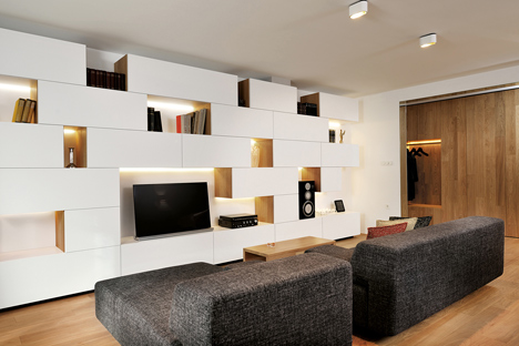 Studio 360 adds walls of modular shelving and storage to Slovenian apartment