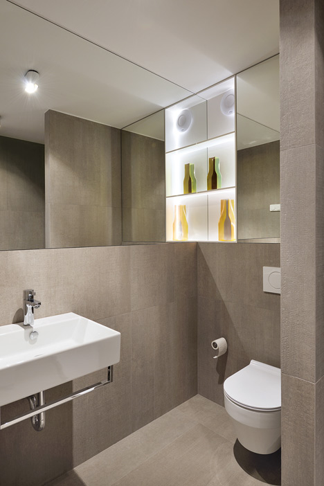Studio 360 adds walls of modular shelving and storage to Slovenian apartment