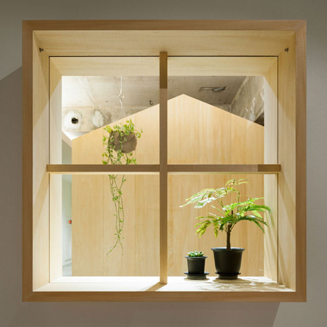 Garden-like office interior by Tsubasa Iwahashi boasts hanging baskets and a wooden shed