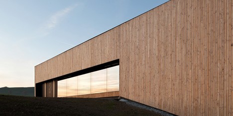 Timber walls feature narrow vertical slices at Virdis Architecture's Lussy Sports Hall