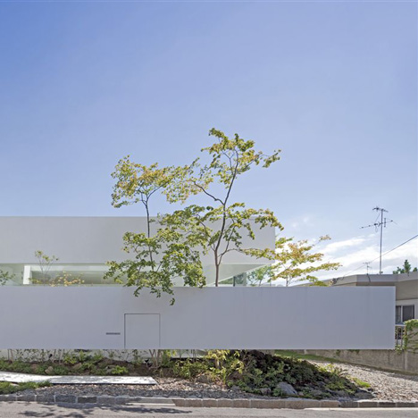 Floating fence surrounds house and doll-making atelier by UID Architects