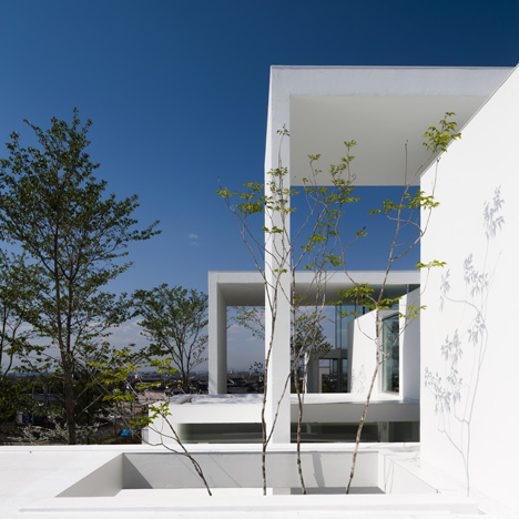 Rectangular arches frame rooms and gardens at Cosmic House by UID Architects