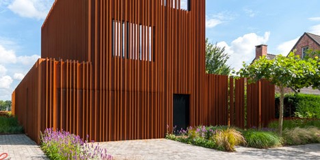 The Corten House by DMOA architecten is surrounded by weathered steel fins