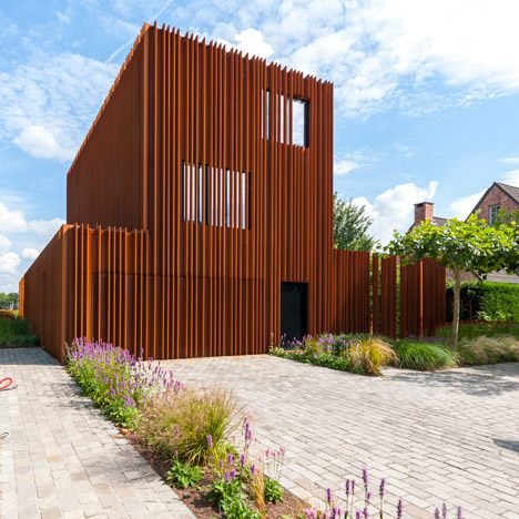 The Corten House by DMOA architecten is surrounded by weathered steel fins