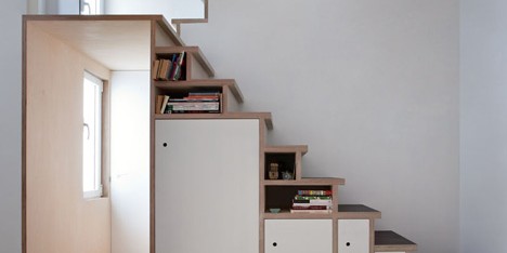 Plywood staircase by Buj+Colón Arquitectos integrates shelves and cupboards for a small flat