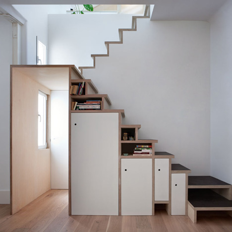 Plywood staircase by Buj+Colón Arquitectos integrates shelves and cupboards for a small flat