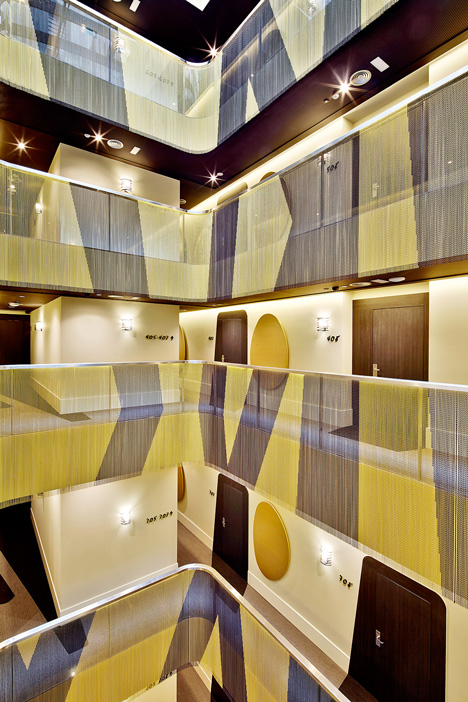 A bold graphic treatment is spread through the atrium at the Vincci Gala Hotel, Barcelona. Interior design by TBI Architects