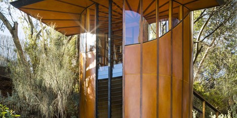 A tube of striped orange wood encloses Max Pritchard’s treetop studio