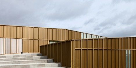 Ateliers O-S adds golden metal walls to cultural centre beside a French cemetery