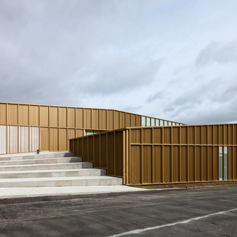 Ateliers O-S adds golden metal walls to cultural centre beside a French cemetery