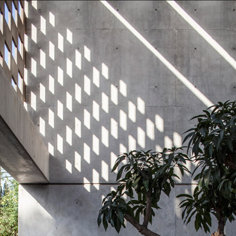 Perforated screens cast graphic shadow patterns over concrete house by Pitsou Kedem