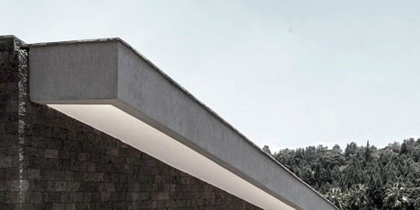 Hewn sandstone walls and an overhanging roof enclose a hillside home in Nairobi